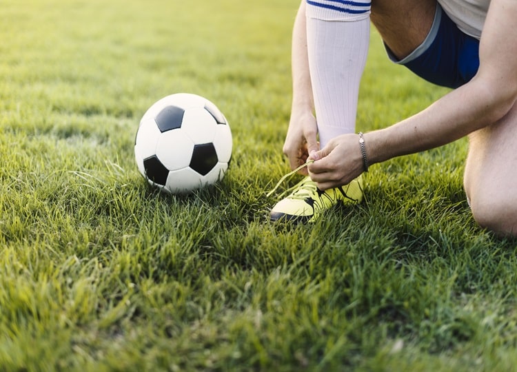 crop-sportsman-tying-laces-field